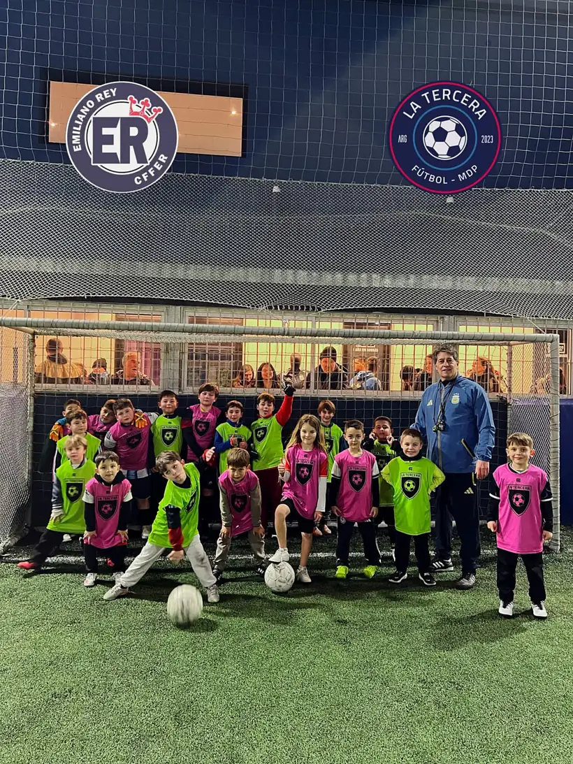 El plantel de la escuelita posando frente al club con el profe